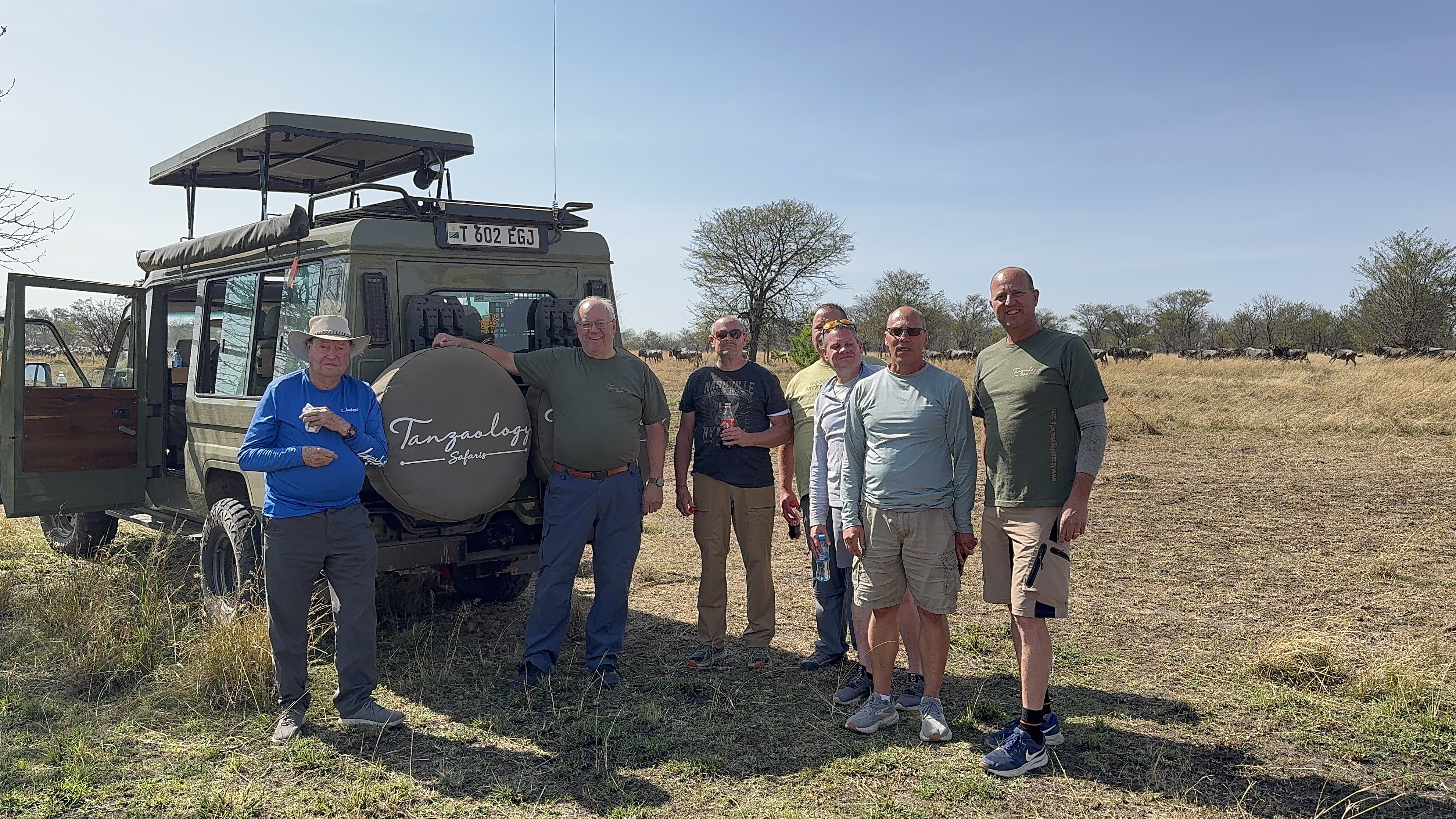 Tanzaology guests and guides beside the safari fleet